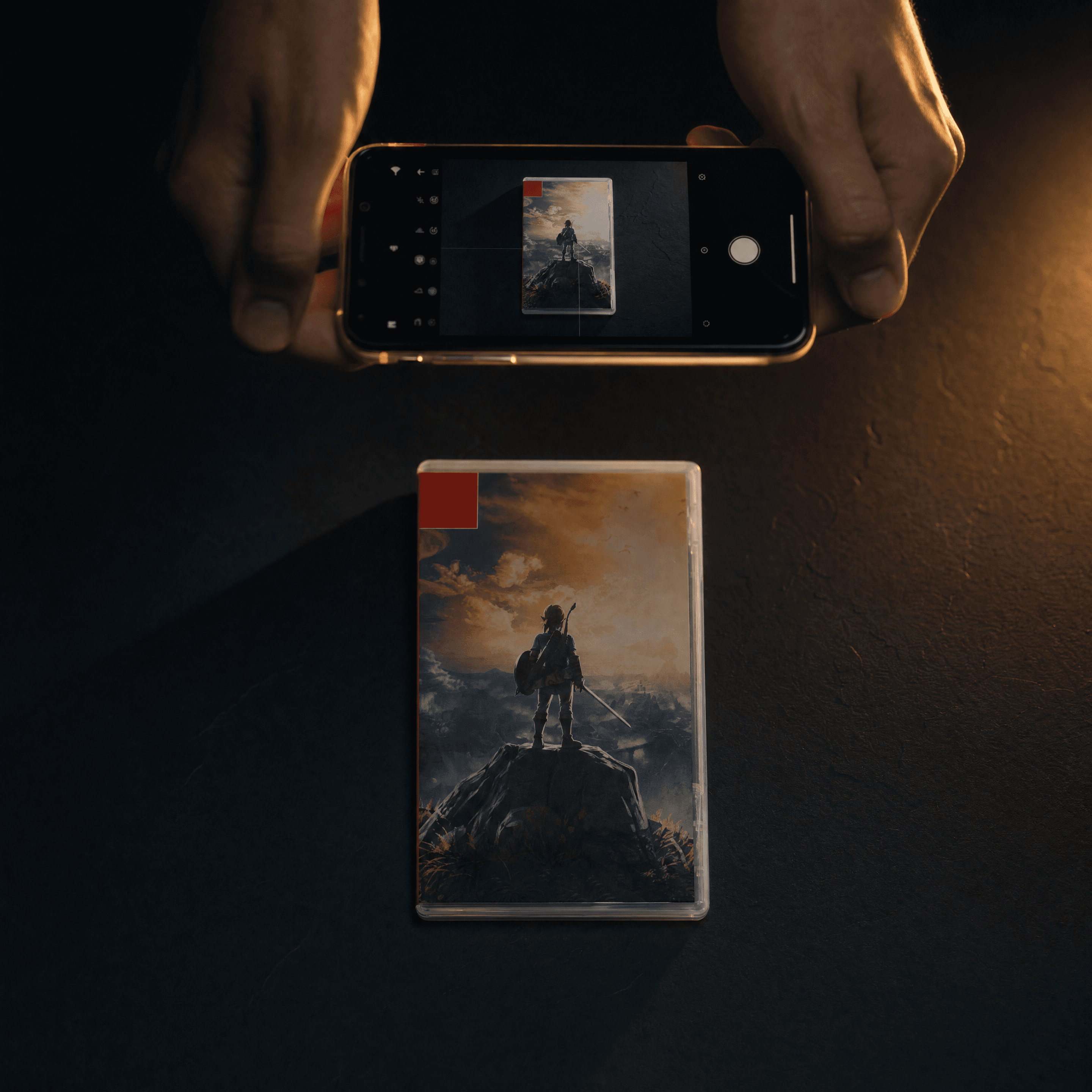 Mains tenant un smartphone pour photographier un jeu